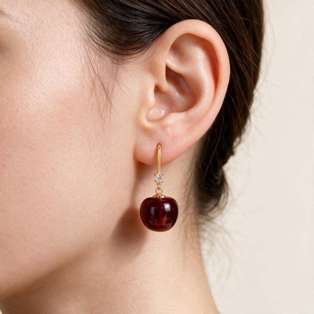 Cherry drop earring worn at the earlobe