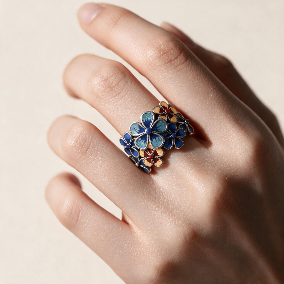 Enamel floral ring worn on a hand