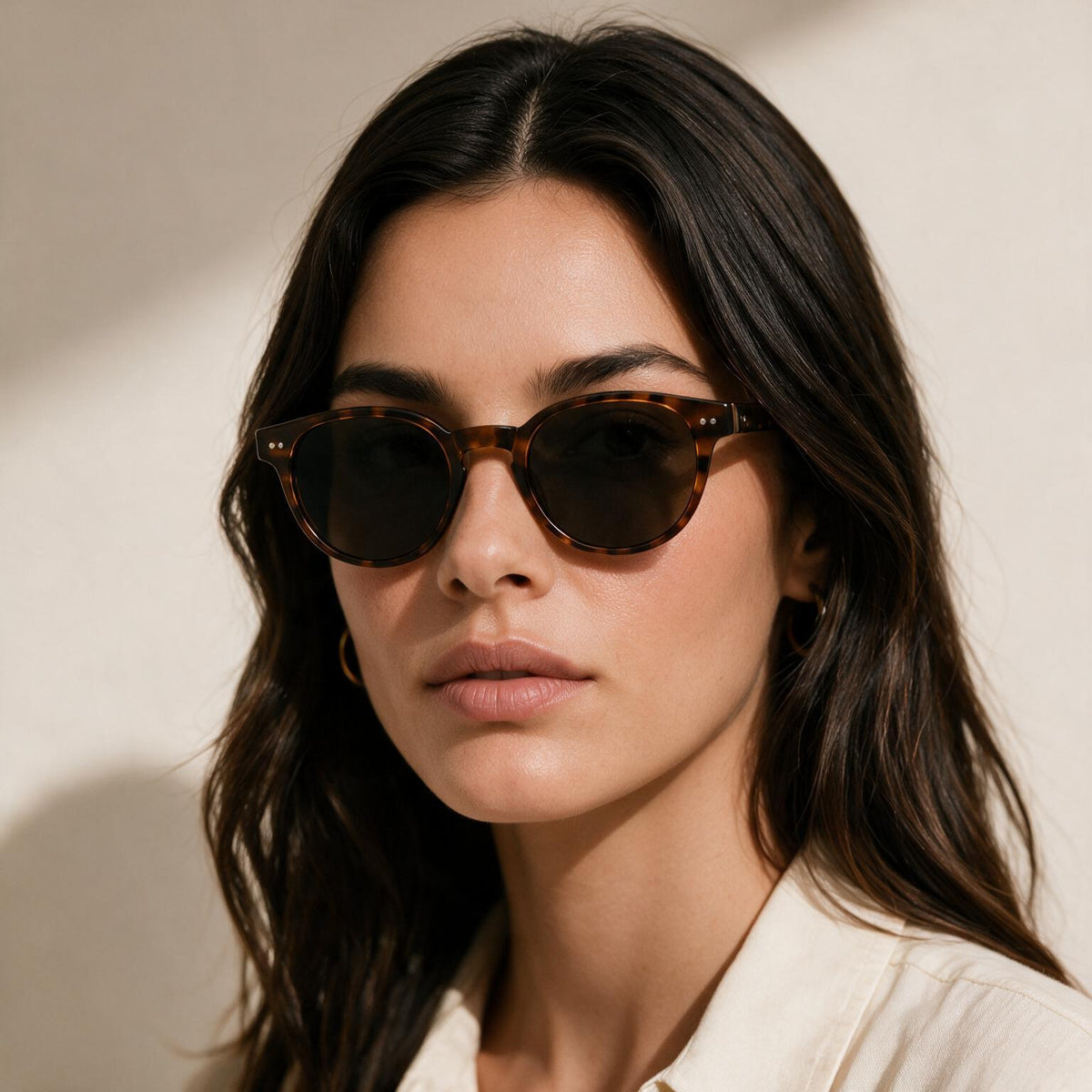 Woman wearing round tortoiseshell sunglasses
