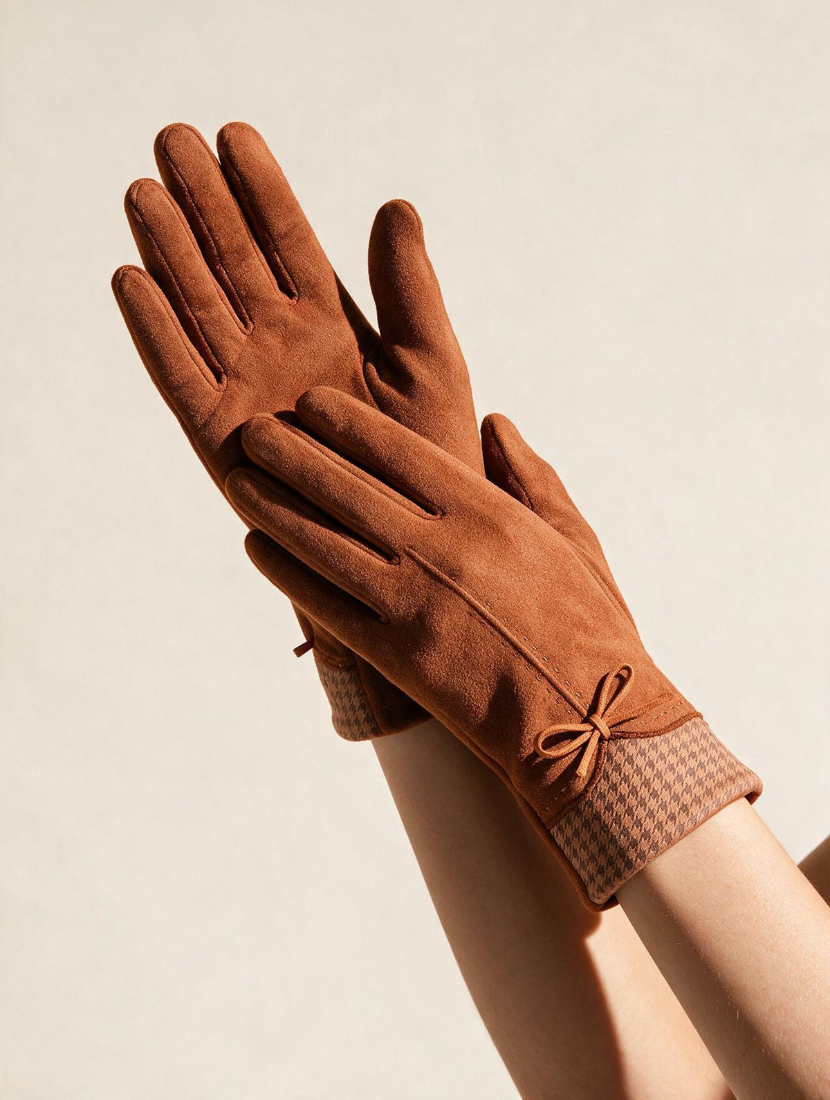 Rust suede gloves with houndstooth cuff and bow, worn